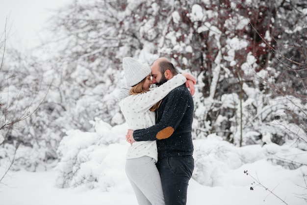 Coppie che giocano con la neve nella foresta