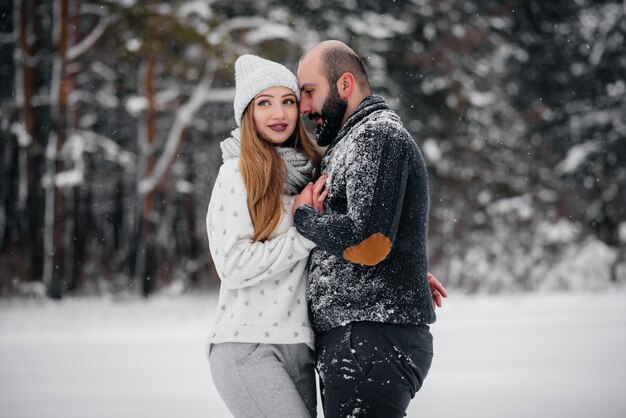 Coppie che giocano con la neve nella foresta