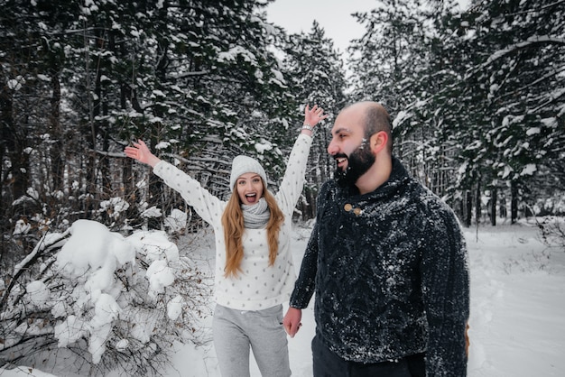 Couple playing with snow in the forest