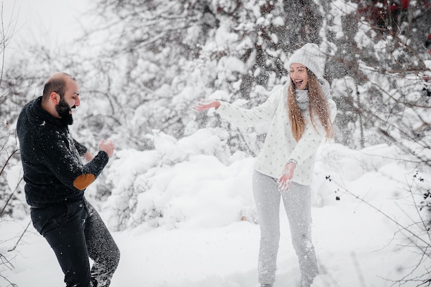 森の中の雪で遊ぶカップル