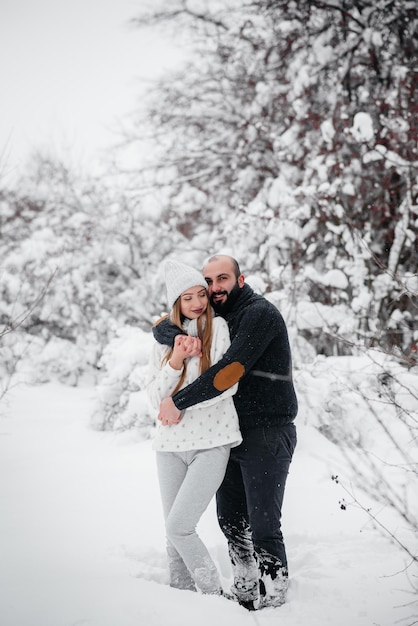 Couple playing with snow in the forest.