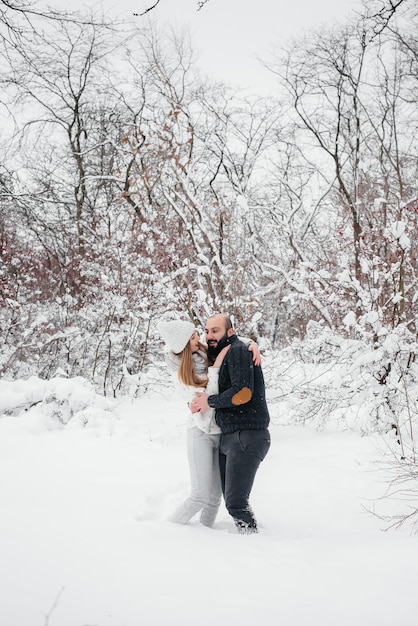 Couple playing with snow in the forest.