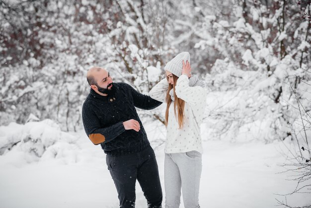 Couple playing with snow in the forest