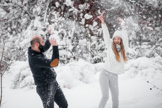 Coppie che giocano con la neve nella foresta