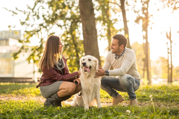 Couple playing with their dog in the park