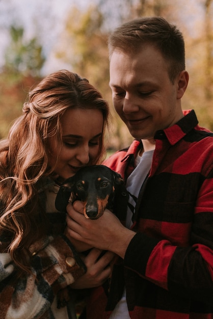 Photo couple playng with dog in the park