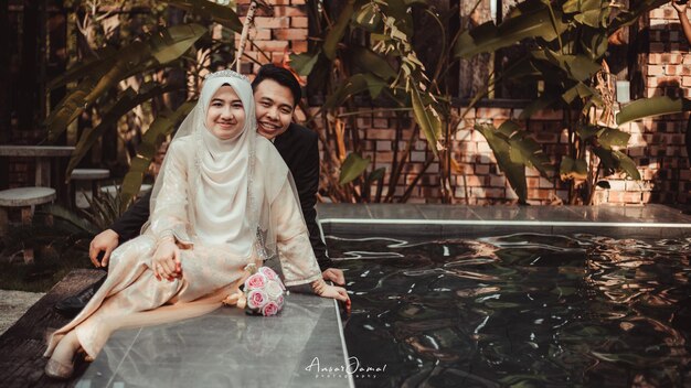 A couple poses by the pool at the first wedding of the year.