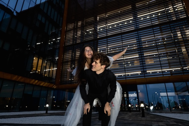 Photo a couple poses in front of a building with the word opera on the left.