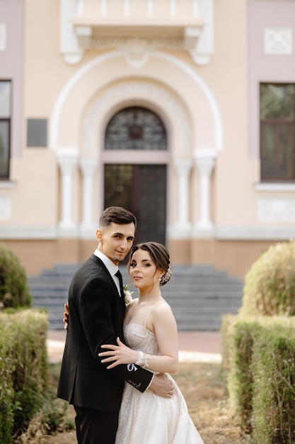 a couple poses for a photo in front of a building