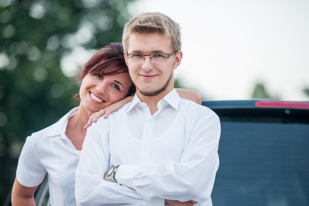 Couple posing by a car