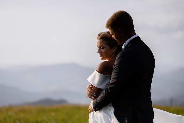 Couple Posing On Hilll And Hugging