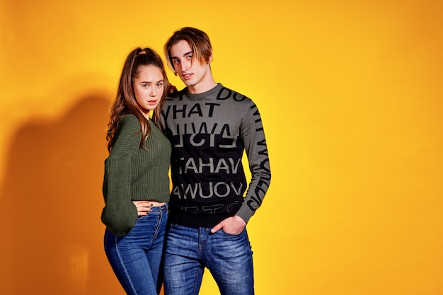 Photo couple posing in jeans type commercial fashion style on yellow wall