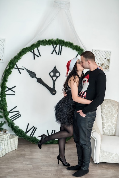 Photo couple posing near clock showing midnight at studio