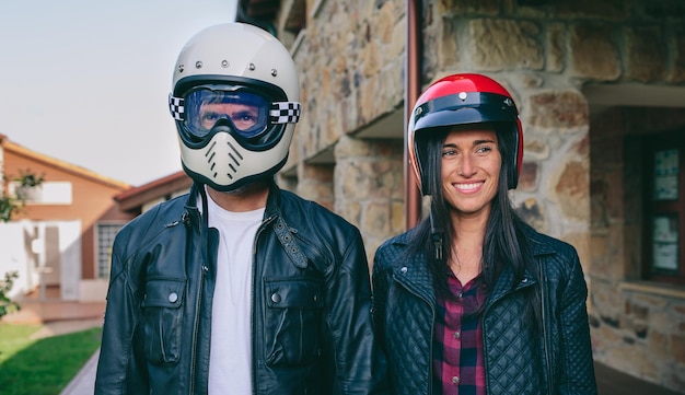 Couple posing with motorcycle helmets