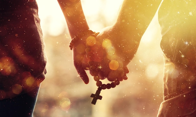 Photo couple praying together. holding rosary in hand.