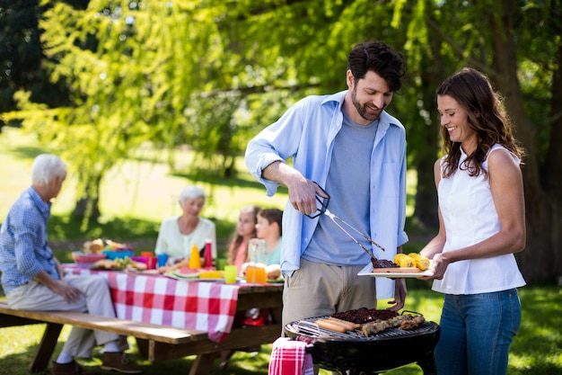 Coppia preparazione barbecue nel parco