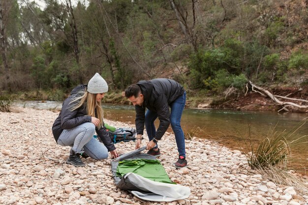 Couple preparing tent for camping