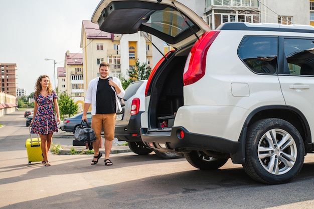 Couple put bags in car trunk. road trip concept