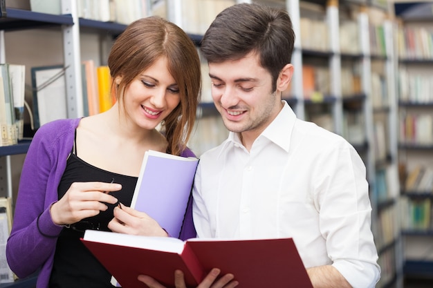 Couple reading a book in a library