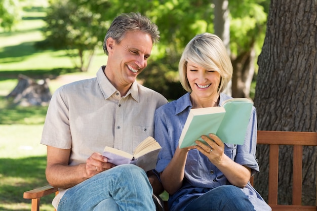 Couple reading books on bench