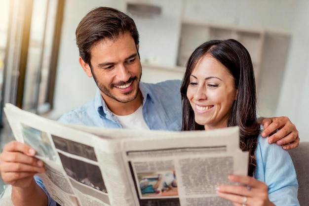 couple reading newspaper in living room at home interior man woman in love together