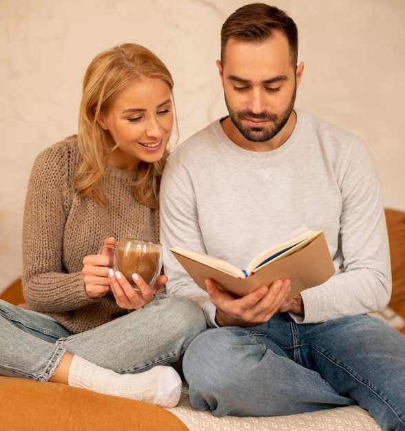 Foto coppia lettura insieme al chiuso