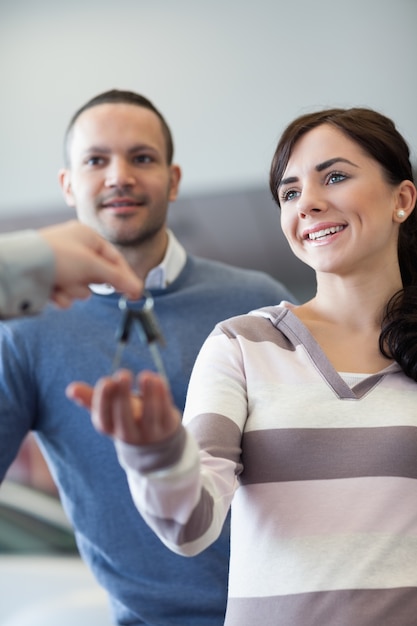 Couple receiving keys from a car dealer