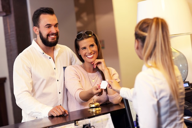 couple and receptionist at counter in hotel