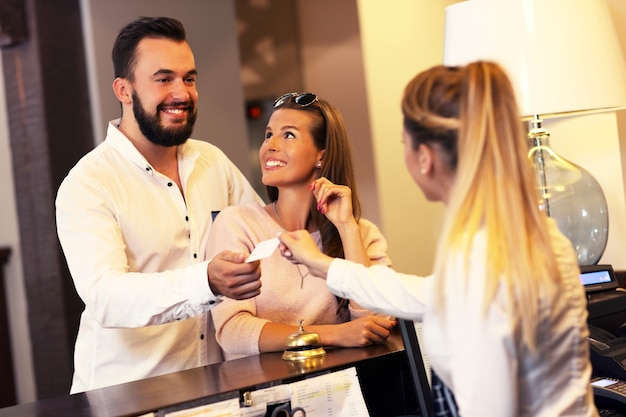 couple and receptionist at counter in hotel