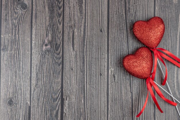 Coppia di cuori glitter rossi su fondo di legno scuro. vista dall'alto, distesi, copia spazio. buon san valentino carta. concetto di amore.