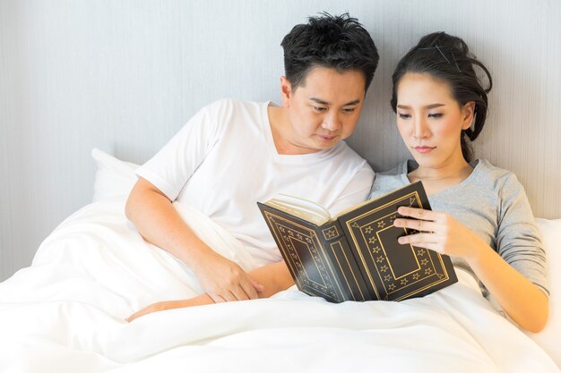 Couple reding book in bed