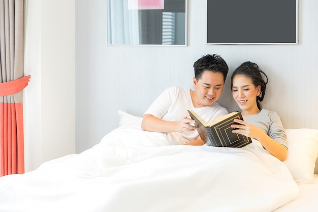 Couple reding book in bed