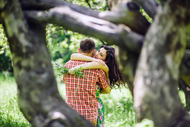 사진 커플은 녹색 정원에서 휴식을 취합니다. 사랑스러운 커플은 녹색 풀밭에서 산책합니다.