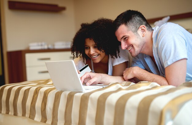 Couple at relaxing at home, watching at laptop.