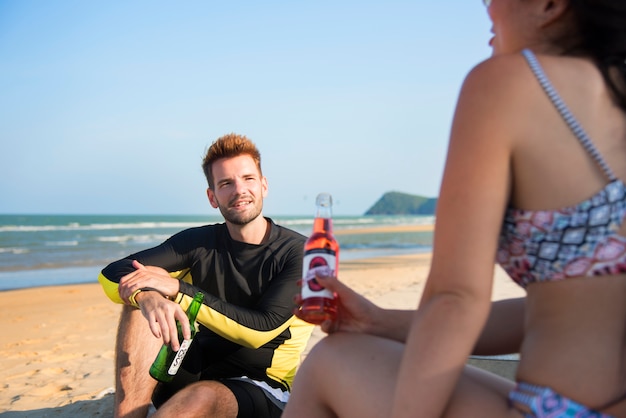 해변에서 맥주와 함께 편안한 커플