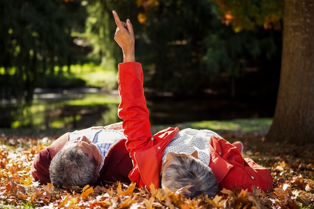 Photo couple resting on autumn leaves