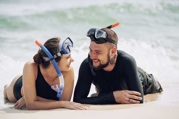 Couple resting on sand