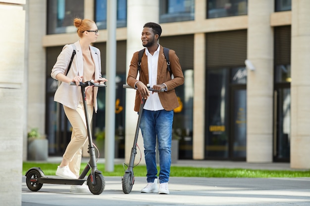couple riding electric scooters in city