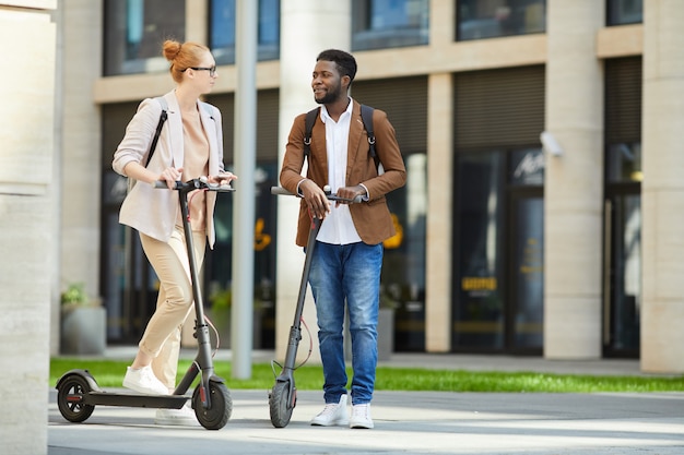 Coppia in sella a scooter elettrici in città