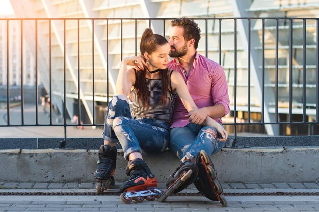 Couple on rollerblades sitting two people in the street time spent together is priceless