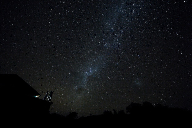 Coppie sul tetto che guardano modo mliky e stelle nel cielo notturno sull'isola di bali.