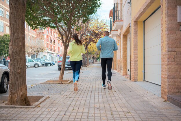 A Couple Running Down a Street