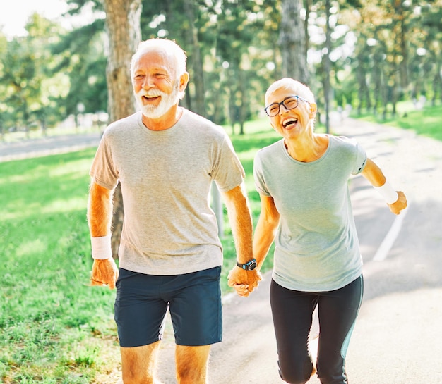 Couple running on the track for exercising being fit and active holding hands together