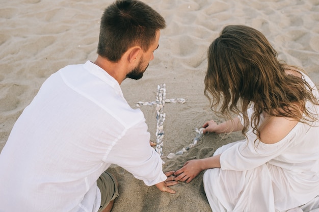 couple on the sandy shore with shells