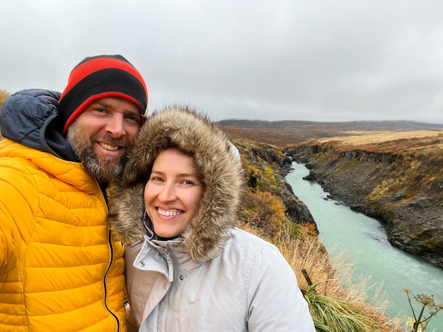 Couple selfie smiling overlooking a river in iceland