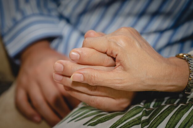 Photo couple senior holding hands while sitting together on sofa at home