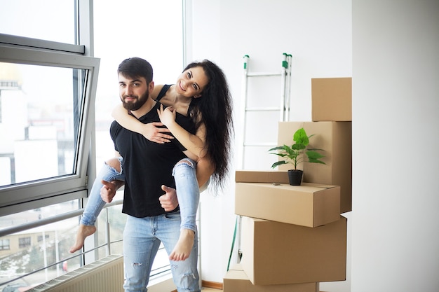 Couple showing keys to new home hugging looking at camera