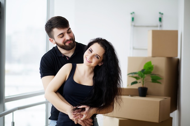 Couple showing keys to new home hugging looking at camera