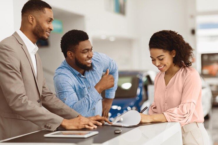 Photo couple signing papers with car dealer buying auto in dealership
