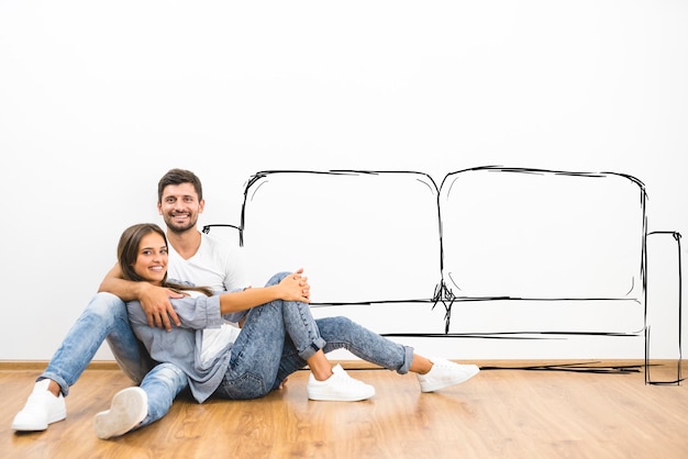 Photo the couple sit near the wall with illustrations